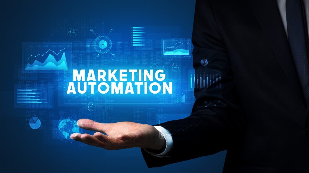 Ejecutivo mostrando un concepto visual de marketing automation con gráficos y datos