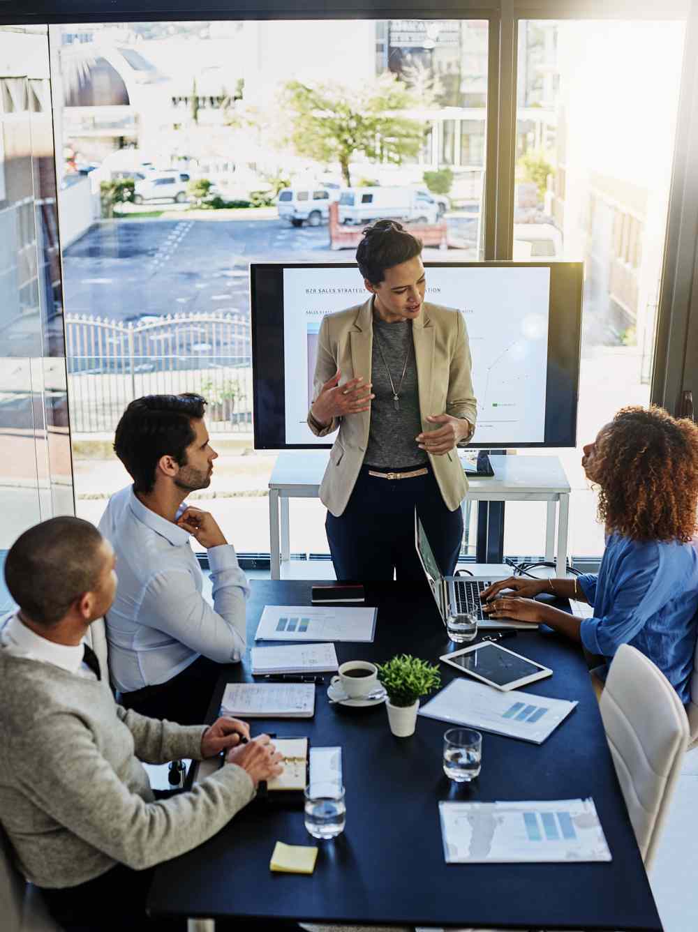 Consultora liderando una reunión de estrategia B2B con su equipo para comparar Salesforce, HubSpot y otros CRM.