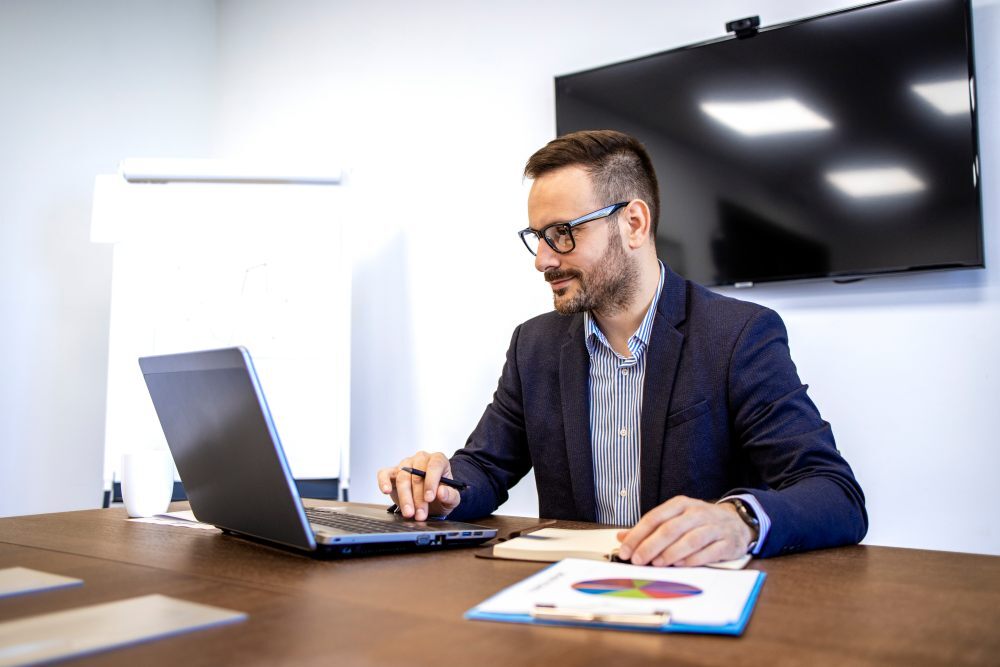 Director de operaciones revisando el presupuesto en su portátil para calcular cuánto cuesta HubSpot en España y analizar su coste total.